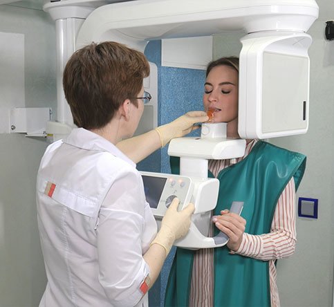 Process of examination teeth of young woman by using panoramic and cephalometric X-Ray scanner